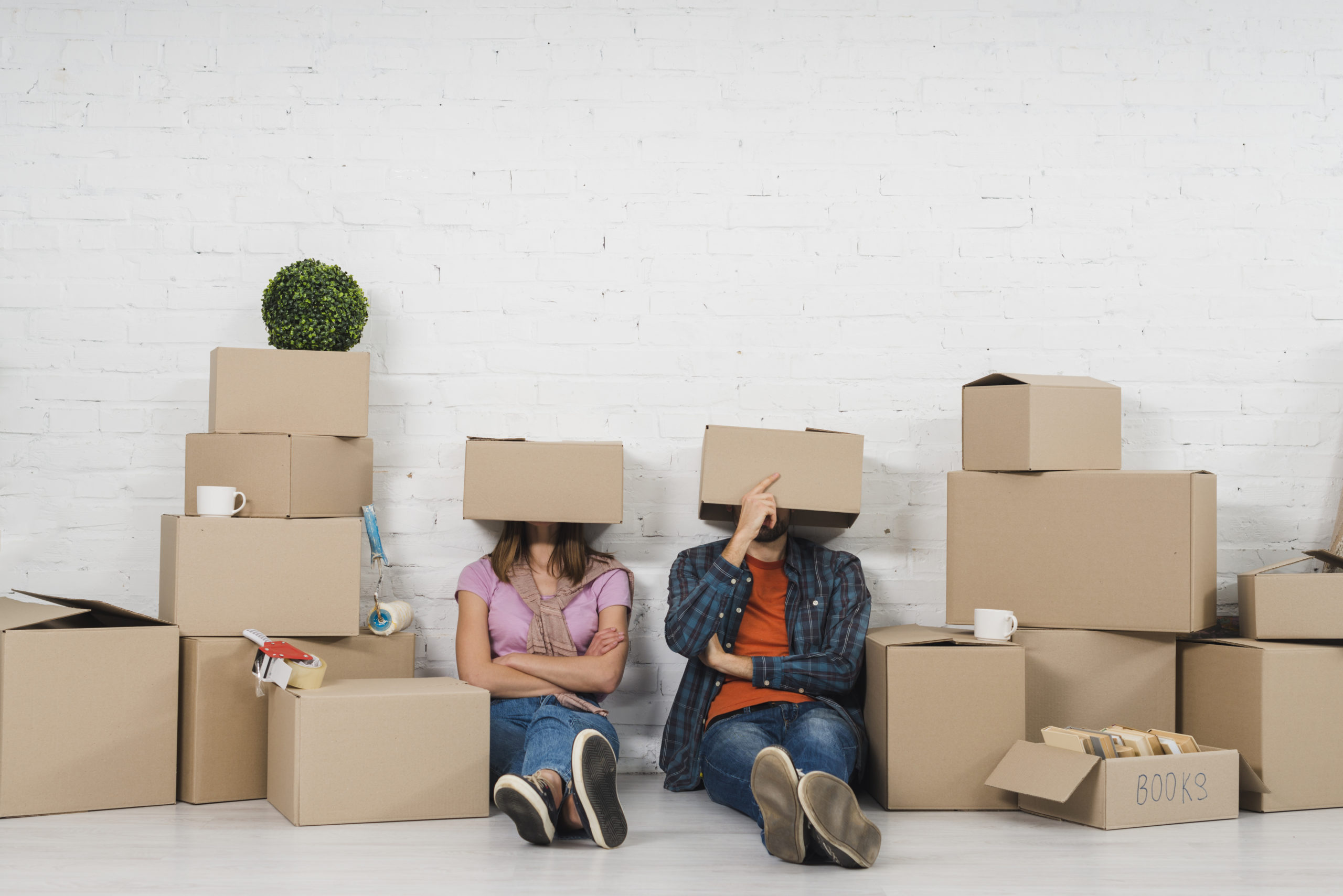 A young couple with moving boxes over their heads